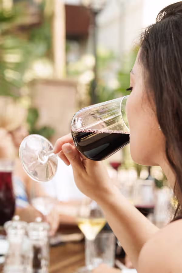 Mujer bebiendo copa de vino en Restaurante azura